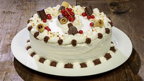 torta di compleanno decorata con panna montata e ciuffetti