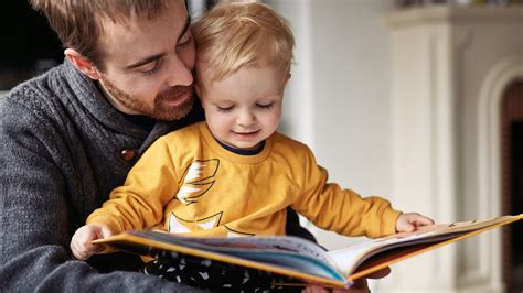 bambino che legge un libro con l'aiuto di un adulto