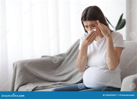 Donna incinta che si soffia il naso