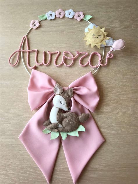 Dettaglio di un fiocco nascita rosa con pizzi e fiorellini