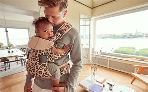 genitore che passeggia con bambino nel marsupio