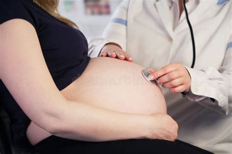 Medico che visita una donna incinta