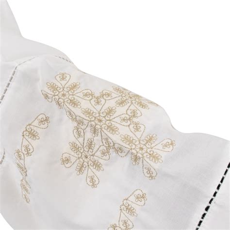 Dettaglio di un camice bianco con ricami