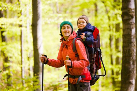 famiglia che cammina con zaino porta bebè in montagna