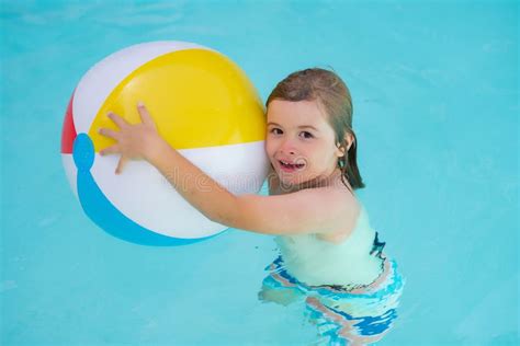 Bambino che gioca felice in piscina con pannolino da nuoto