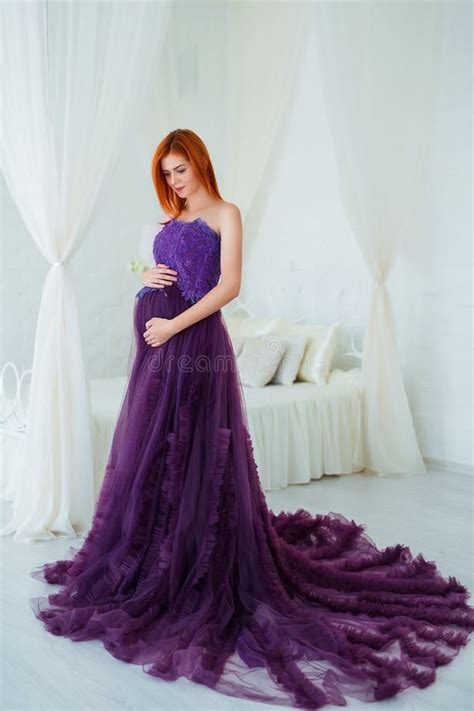 Donna incinta che sceglie un vestito elegante