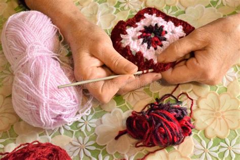 mano che lavora all'uncinetto un pezzo di stoffa