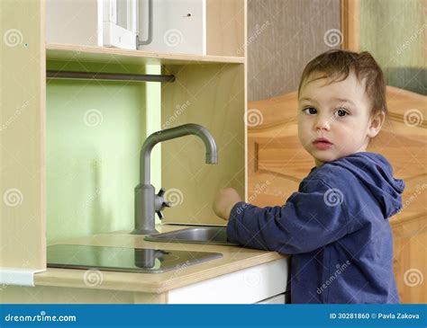 Bambino che gioca con una cucina giocattolo