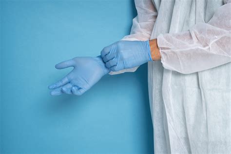 Persona che indossa guanti e occhiali protettivi mentre lavora con sostanze chimiche