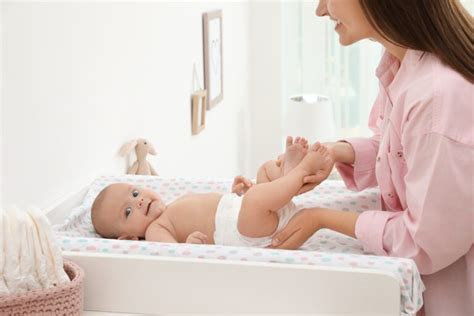 Bambino che viene cambiato su un fasciatoio con protezioni laterali