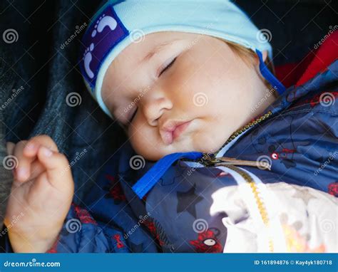 bambino che dorme nella cappottina di un passeggino