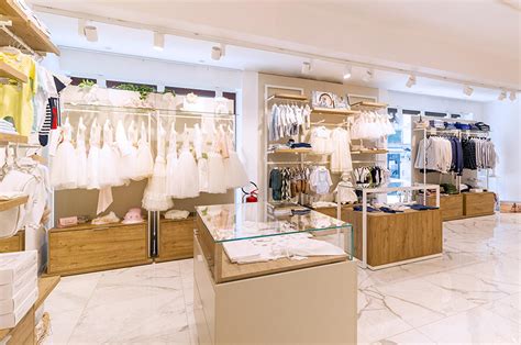 Interno negozio Prénatal con esposizione di abbigliamento per neonati e accessori