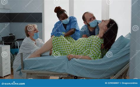 Ostetrica che assiste una neo-mamma con il suo neonato