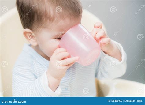 Bambino che beve da una tazza antigoccia