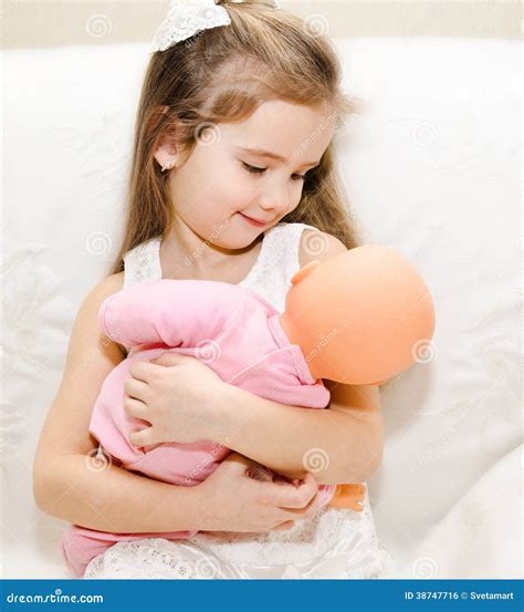 Bambina che gioca con cesta culla e bambola