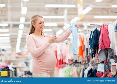 Donna incinta che prova vestiti diversi