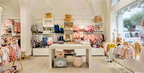 Bambini che provano giacche da pioggia in un negozio di abbigliamento per bambini
