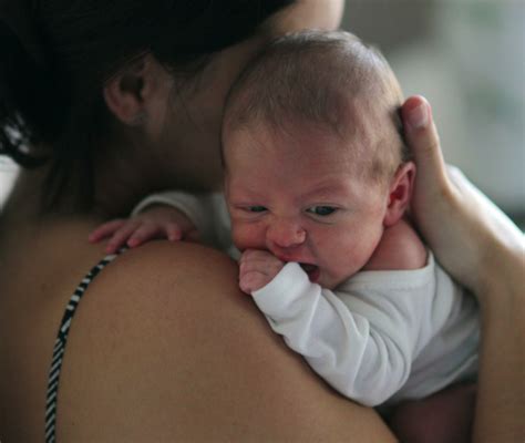 Una donna che tiene in braccio un neonato, con uno sguardo amorevole.
