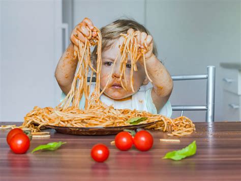 bambino mangia frutta secca con le mani