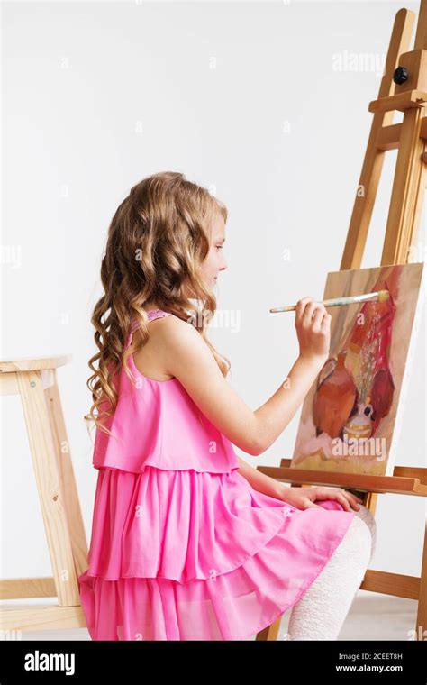 Bambina che dipinge conchiglie colorate