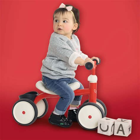 Bambino che guida una macchinina cavalcabile rossa
