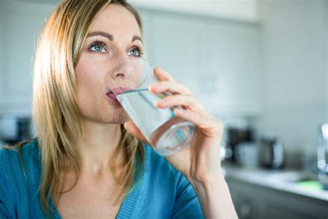 Donna che beve acqua fresca da un bicchiere