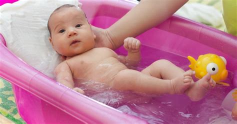 Genitore che massaggia il neonato dopo il bagnetto
