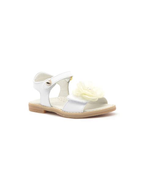 primo piano di un sandalo bianco elegante per bambina con dettagli floreali