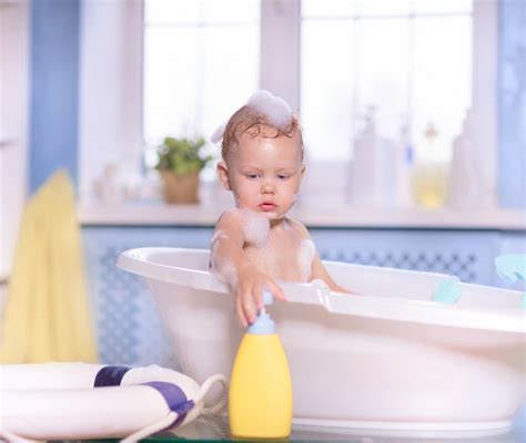 Bambino che fa il bagnetto in una vaschetta