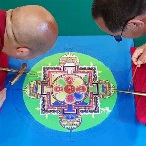 Monaci tibetani al lavoro su un mandala di sabbia