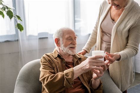 Immagine di un anziano sorridente che respira liberamente, con un aspiratore per catarro discreto sullo sfondo.
