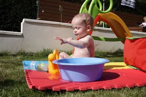 neonato che gioca con giochini nell'acqua