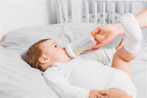 Bambino che beve da un biberon preparato con la macchina Perfect Prep