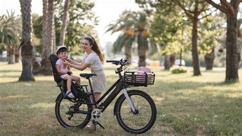 Bambina felice su una bicicletta con seggiolino