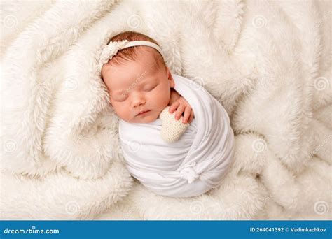 Neonata che dorme vestita di bianco