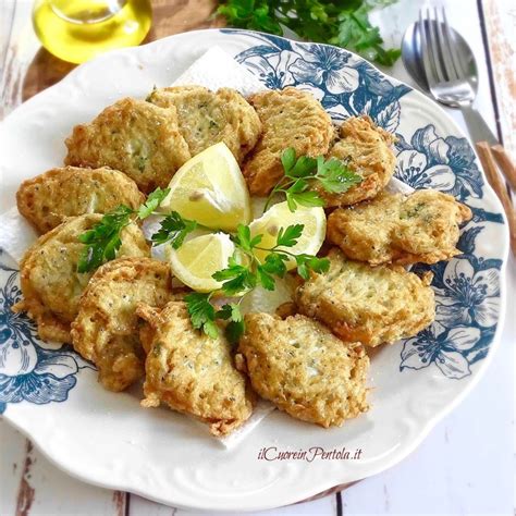 Frittelle di neonata dorate e croccanti su un piatto da portata con spicchi di limone