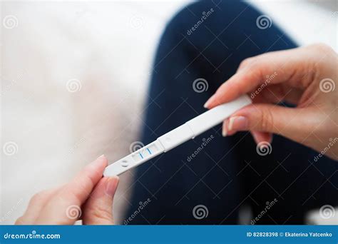 Donna che tiene un test di gravidanza positivo