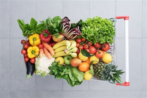 Carrello della spesa pieno di frutta, verdura e prodotti di prima necessità