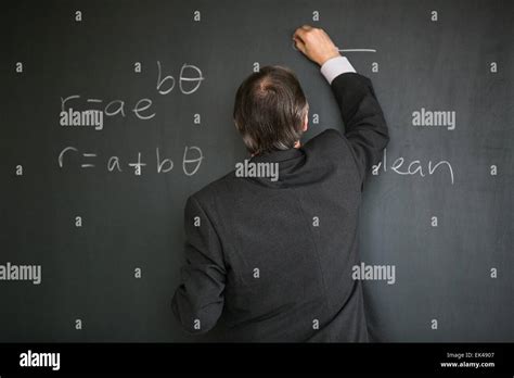 Docente che spiega una formula matematica alla lavagna