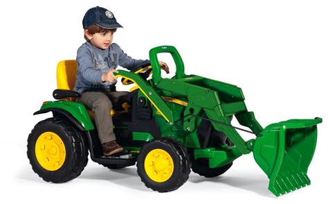 Bambino che gioca con la ruspa elettrica Peg Perego John Deere