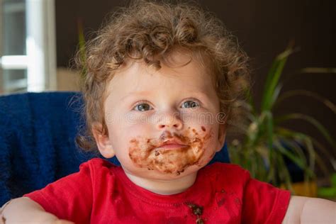 Un bambino che si sporca il viso mangiando una pappa