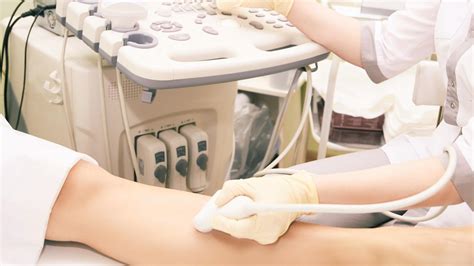 Immagine di un medico che esegue un ecocolordoppler alle gambe