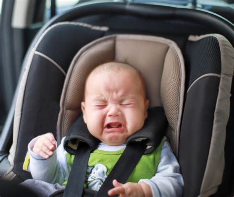 Bambino che piange nel seggiolino auto