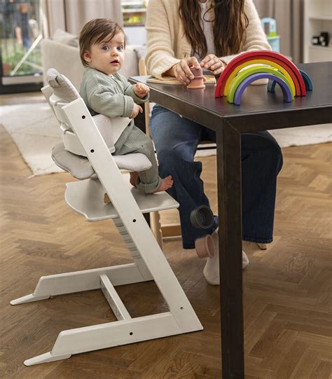 famiglia che mangia a tavola con seggiolone Stokke Tripp Trapp