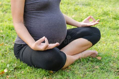 Donna incinta che fa yoga in un parco