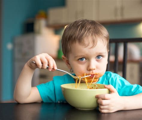 bambino che mangia con il cucchiaino