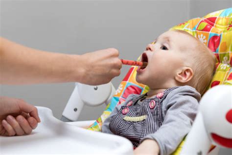 bambino che prende lo sciroppo con la siringa