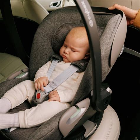Famiglia che aggancia un seggiolino auto su una base Isofix