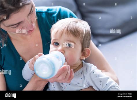 bambino che beve dal biberon con espressione rilassata
