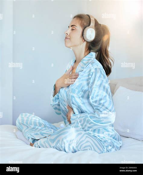 Una ragazza seduta sul letto, con le cuffie, circondata da un'atmosfera cupa.